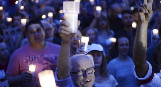Anti-government protesters raise candles, as they gather in front of the Supreme Court in Warsaw, Poland, Sunday, July 23, 2017