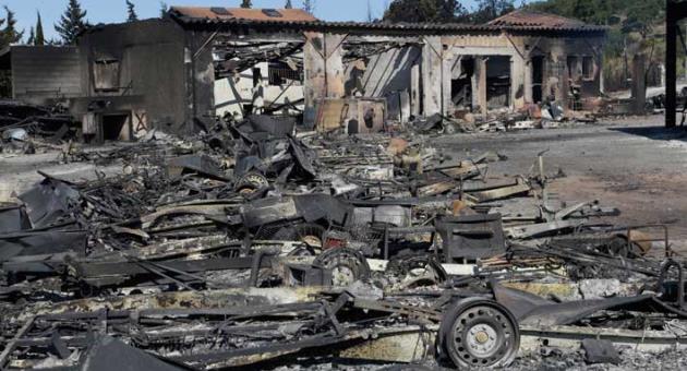 The charred remains of burnt caravans at a warehouse in La Londe-les-Maures on the French Riviera, Wednesday, July 26, 2017. 