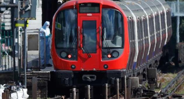 A police forensic officer stands beside the train where an incident happened, that police say they are investigating as a terrorist attack, at Parsons Green subway station in London, 