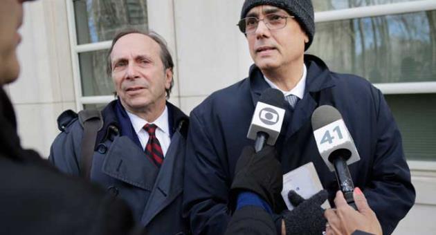 Manuel Burga, right, talks to reporters after leaving federal court in the Brooklyn borough of New York, Tuesday, Dec. 26, 2017
