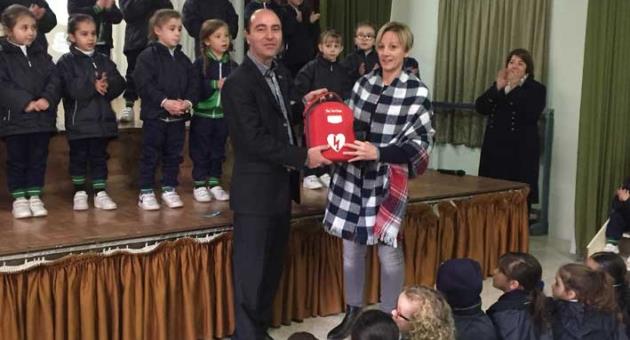 Mr Adrian Friggieri presenting the defibrillator to the head of St Joseph School Sliema (Junior) Mrs Mariucca Fenech. 