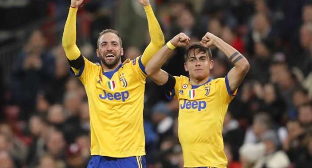 Juventus' Paulo Dybala, right, celebrates with his teammate Gonzalo Higuain after scoring his side second goal during the Champions League, round of 16, second-leg soccer match between Juventus and Tottenham Hotspur, at the Wembley Stadium in London, Wednesday, March 7, 2018. (AP Photo/Frank Augstein)