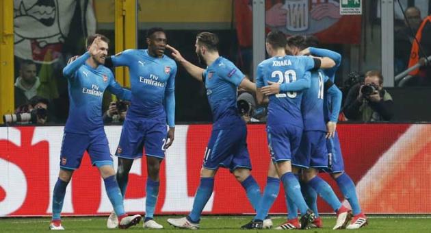 Arsenal's Aaron Ramsey, left, celebrates with teammates after scoring his side's second goal during the Europa League, round of 16 first-leg soccer match between AC Milan and Arsenal, at the Milan San Siro stadium, Italy, Thursday, March 8, 2018. (AP Photo/Antonio Calanni)