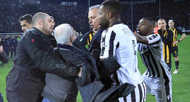 PAOK owner, businessman Ivan Savvidis, second from left, approaches AEK Athens' Manager Operation Department Vassilis Dimitriadis, center, as his bodyguard and PAOK's players Fernando Varela, second from right, and Djalma Campos, right, try to stop him during a Greek League soccer match between PAOK and AEK Athens in the northern Greek city of Thessaloniki, Sunday, March 11, 2018. A disputed goal at the end of the Greek league match led to a pitch invasion by Savvidis, who appeared to be carrying a gun. Savvidis came on the field twice. It's unclear this photos shows his first time or second. (InTime Sports via AP)