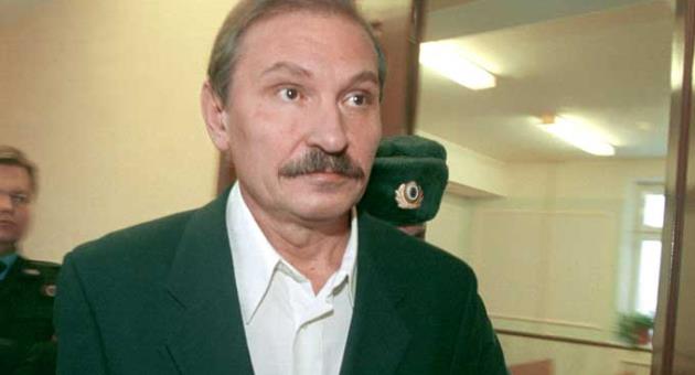 In this Tuesday, Dec. 19, 2000 file photo, ex-deputy director general of Aeroflot airlines company Nikolai Glushkov leaves the Lefortovsky court escorted by police officers, after the judge refused to release him on bail, in Moscow