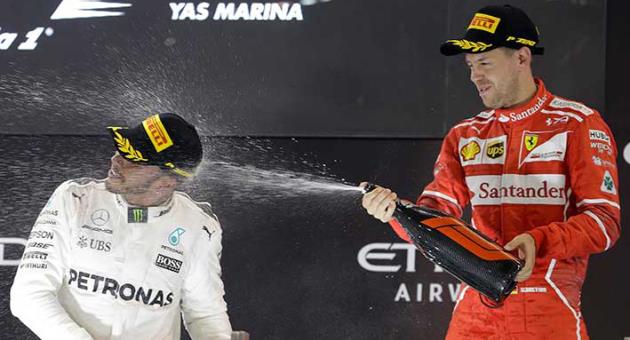 A Sunday, Nov. 26, 2017 file photo showing Mercedes driver Lewis Hamilton of Britain, left, and Ferrari driver Sebastian Vettel of Germany celebrating after the Emirates Formula One Grand Prix at the Yas Marina racetrack in Abu Dhabi, United Arab Emirates. Lewis Hamilton and Sebastian Vettel start the Formula One season within touching distance of further greatness. A fifth world title would move one of them level with Juan Manuel Fangio and second only to Michael Schumacher’s seven. (AP Photo/Luca Bruno, File)