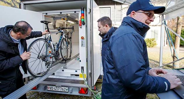 A technician puts a bicycle into the X-Ray machine in front of the UCI President David Lappartient, 2nd left, during a UCI's press conference about Fight against technological fraud, in Geneva, Switzerland, Wednesday, March 21, 2018. (Salvatore Di Nolfi/Keystone via AP)