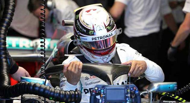 Mercedes driver Lewis Hamilton of Britain struggles to get our of his car at the end of the first practice session at the Australian Formula One Grand Prix in Melbourne, Friday, March 23, 2018. The first race of the 2018 seasons is on Sunday. (AP Photo/Rick Rycroft)