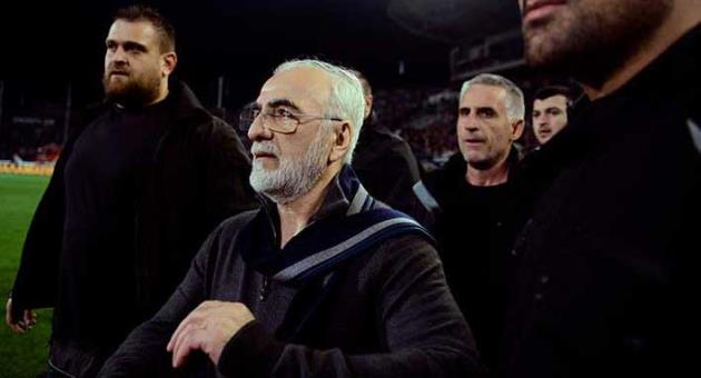 In this Sunday, March 11, 2018 file photo, PAOK owner, businessman Ivan Savvidis, center, walks on the pitch escorted by his bodyguards during a Greek League soccer match between PAOK and AEK Athens in the northern Greek city of Thessaloniki. Savvidis was banned for three years on Thursday, March 29, 2018, for his part in violence during a match against AEK Athens, including running onto the field with a holstered pistol on his hip. (AP Photo, File)