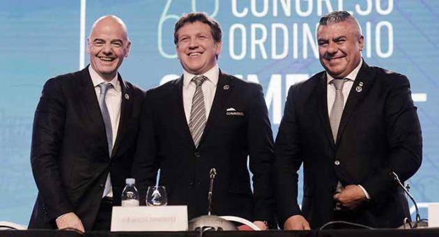 FIFA President Gianni Infantino, left, Dominguez, center, president of the South American Football Confederation, CONMEBOL, and Claudio Tapia, president of the Argentine Football Association, right, pose for a photo during CONMEBOL's annual conference in Buenos Aires, Argentina, Thursday, April 12, 2018. CONMEBOL has asked FIFA to expand the World Cup to 48 teams for the 2022 tournament in Qatar. (AP Photo/Martin Ruggiero)