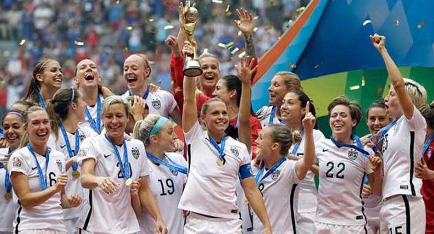 In this, July 5, 2015 file photo, the United States Women's National Team celebrates with the trophy after they beat Japan 5-2 in the FIFA Women's World Cup soccer final in Vancouver, British Columbia, Canada. FIFA is making a concession to women's football and will start funding business-class flights for some 2019 Women's World Cup teams' travel to France. FIFA official Emily Shaw also tells a women's sports law conference total prize money will 