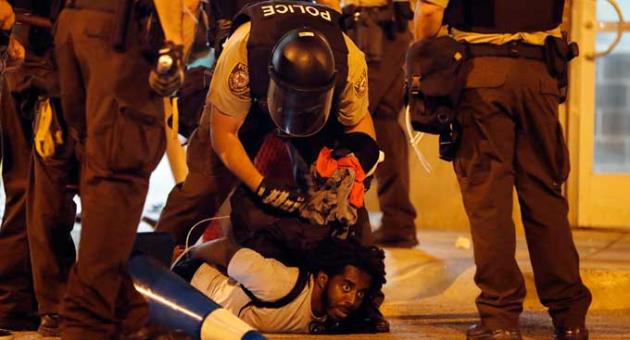 Police arrest a man as demonstrators march in response to a not guilty verdict in the trial of former St. Louis police officer Jason Stockley, Sunday, Sept. 17, 2017, in St. Louis