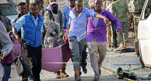 Somalis use a sheet to carry a man wounded in a blast away to an ambulance, in the capital Mogadishu, Somalia Saturday, Oct. 14, 2017. 