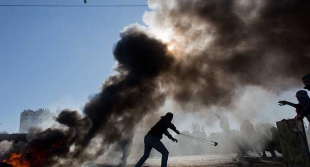 Palestinian protesters burn tires and clash with Israeli troops following protests against U.S. President Donald Trump's decision to recognize Jerusalem as the capital of Israel, in the West Bank city of Ramallah, Friday, Dec. 8, 2017. 