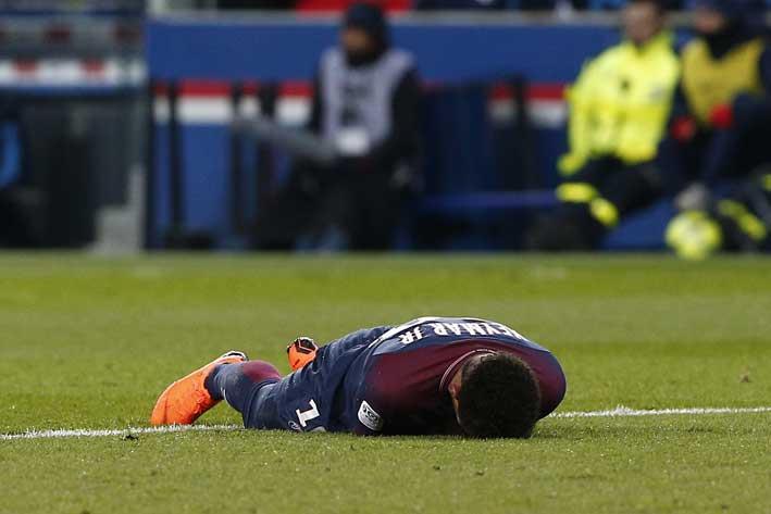 PSG's Neymar lays on the pitch after being fouled during the French League One soccer match between Paris Saint-Germain and Marseille at the Parc des Princes Stadium, in Paris, France, Sunday, Feb. 25, 2018. (AP Photo/Thibault Camus)
