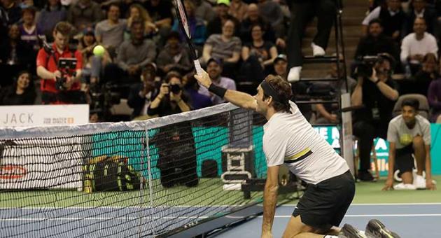 Roger Federer, of Switzerland, hits from his knees as he plays in an exhibition tennis match with partner Bill Gates against Jack Sock and Savannah Guthrie in San Jose, Calif., Monday, March 5, 2018. (AP Photo/Jeff Chiu)