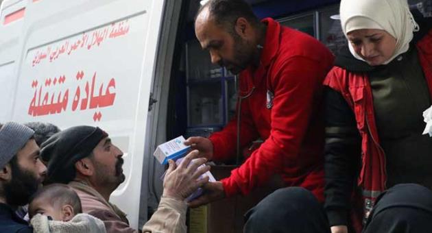 This photo release by the Syrian Red Crescent, shows members of the Syrian Red Crescent distributing medicines for civilians in Douma, eastern Ghouta, a suburb of Damascus, Syria, Monday, March. 5, 2018.