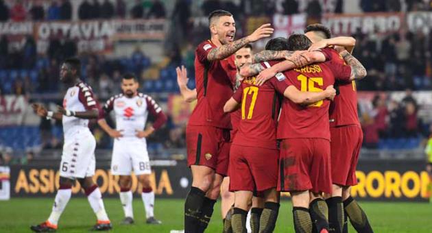 AS Roma's Daniele De Rossi, second from right with back to camera, is hugged by teammates as he celebrates after scoring during a Serie A soccer match between AS and Torino, at the Olympic stadium, in Rome, Friday, March 9, 2018. (Alessandro Di Meo/ANSA via AP)