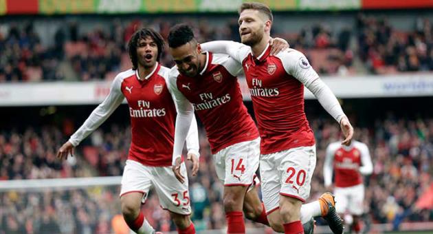 Arsenal's Shkodran Mustafi, right, celebrates after scoring his side's opening goal with Arsenal's Pierre-Emerick Aubameyang, center and Arsenal's Mohamed Elneny during the English Premier League soccer match between Arsenal and Watford at the Emirates stadium in London, Sunday, March 11, 2018. (AP Photo/Matt Dunham)