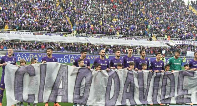 Fiorentina players hold banner reading 