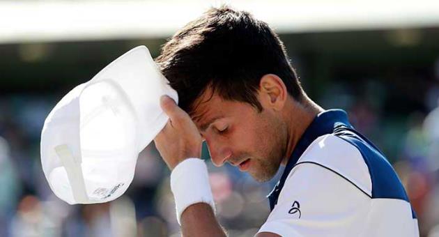 Novak Djokovic, of Serbia, walks to his chair during his match against Benoit Paire, of France, at the Miami Open tennis tournament, Friday, March 23, 2018, in Key Biscayne, Fla. Paire won 6-3, 6-4. (AP Photo/Lynne Sladky)