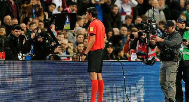 Referee Deniz Aytekin checks the VAR during the international friendly soccer match between England and Italy at the Wembley Stadium in London, Tuesday, March 27, 2018. (AP Photo/Alastair Grant)