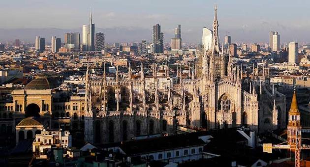 In this Jan. 4, 2017 file phtoo, the pinnacles of the Duomo cathedral are lit by the afternoon sun and backdropped by the new Business Center, in Milan, northern Italy. The Italian Olympic Committee sent a letter of intent to the IOC on Thursday, March 29, 2018, stating its plans of combining Milan and Turin to bid for the 2026 Winter Olympics. (AP Photo/Luca Bruno, files)