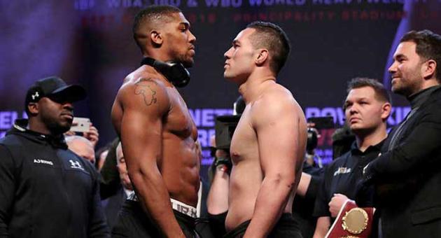Britain's Anthony Joshua, left, and New Zealand's Joseph Parker during the weigh in, at Cardiff's Motorpoint Arena on Friday March 30, 2018, ahead of their world heavyweight unification title fight on Saturday. (Nick Potts/PA via AP)