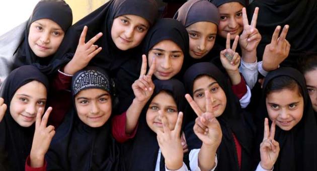 Students of the school of Nobel Peace Prize winner Malala Yousafzai flash victory sign in her hometown of Swat Valley in Pakistan, Friday, March 30, 2018. 