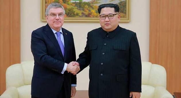 In this photo provided by the North Korean government on Saturday, March 31, 2018, North Korean leader Kim Jong Un, right, poses with International Olympic Committee President Thomas Bach for a photo during a meeting in Pyongyang, North Korea. Bach met with Kim on Friday and said the North Korean leader is committed to having his country participate in the 2020 Tokyo Summer Olympics and the Beijing Winter Games in 2022. Independent journalists were not given access to cover the event depicted in this image distributed by the North Korean government. The content of this image is as provided and cannot be independently verified. Korean language watermark on image as provided by source reads: 