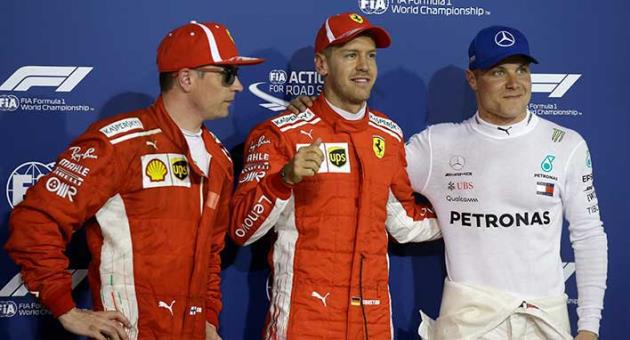 Ferrari driver Sebastian Vettel of Germany, center, who earned pole position, Mercedes driver Valtteri Bottas of Finland, right, who came in third and Ferrari driver Kimi Raikkonen of Finland, who earned the second best time, posing for photos after the qualifying for the Bahrain Formula One Grand Prix, at the Formula One Bahrain International Circuit in Sakhir, Bahrain, Saturday, April 7, 2018. The Bahrain Formula One Grand Prix will take place here on Sunday. (AP Photo/Luca Bruno)