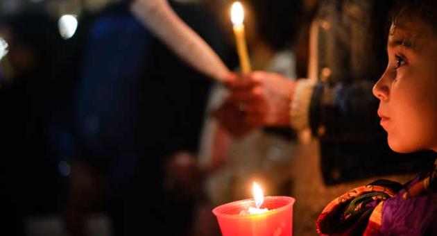 People hold candles as they attend a prayer vigil for terminally ill toddler Alfie Evans, in St. Peter's Square at the Vatican, Thursday, April 26, 2018. 
