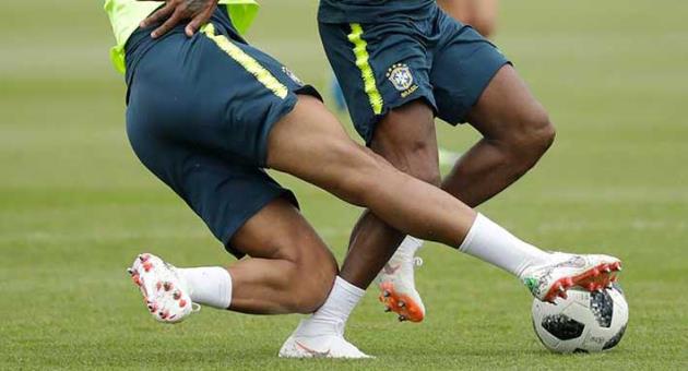Brazil's Fred, right, injures his right ankle from a tackle from Casemiro, which led him to walk off the pitch and receive treatment and then watch from the sidelines during a national soccer squad training session at the training facilities of Tottenham Hotspur football club in Enfield, England, Thursday, June 7, 2018. (AP Photo/Matt Dunham)