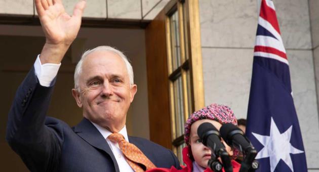 Outgoing Australian Prime Minister Malcolm Turnbull waves while holding his granddaughter Alice during a final press conference before leaving Parliament in Canberra, Friday, Aug. 24, 2018. Australia government lawmakers on Friday elected Treasurer Scott Morrison as the next prime minister
