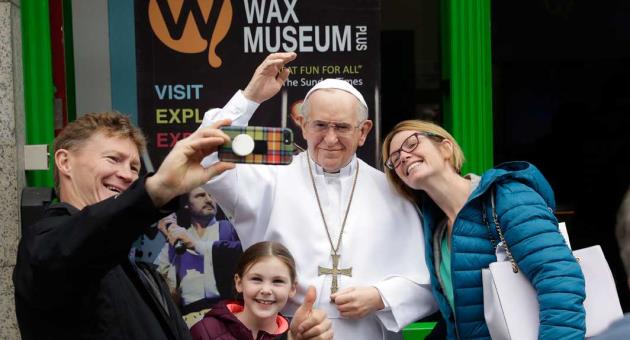 People take a selfie with a recently unveiled waxwork of Pope Francis displayed outside the National Wax Museum in Dublin, Ireland, Friday, Aug. 24, 2018.