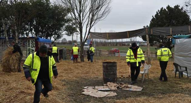 Protestors wearing yellow vests stand in a makeshift camp on a roundabout near Senlis, north of Paris, Thursday, Jan. 10, 2019. With its makeshift grocery, camp beds and community spirit, the large central island about 60 kilometers north of Paris has been transformed over the past two months into an encampment where dozens of yellow vests protesters gather day in day out to organize their long-standing fight against the French government.
