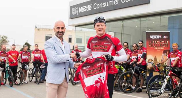 Alfred J. Borg presenting the new Nescafé 3in1 LifeCycle Challenge kit to Alan Curry flanked by cyclists and the back-up team