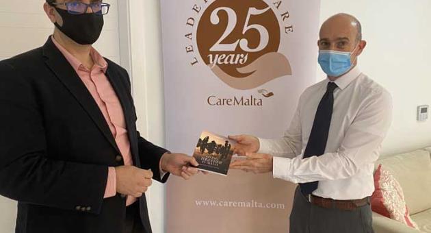 Prof. Adrian-Mario Gellel presenting the handbook to Robert Grech at CareMalta’s head office in Mosta