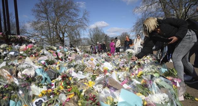 A woman places a floral tribute for slain woman Sarah Everard, at the bandstand in Clapham Common, London, Friday March 19, 2021. Photo AP