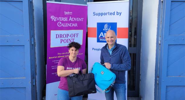 Matthew von Brockdorff, managing director and CEO of Atlas Insurance, presenting the two laptops to Barbara Caruana, Foodbank Lifeline Foundation manager