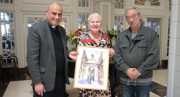 Fr Charles Cini and Julian Holland presenting the painting to Ms Robyn Pratt, General Manager of The Phoenicia Malta.