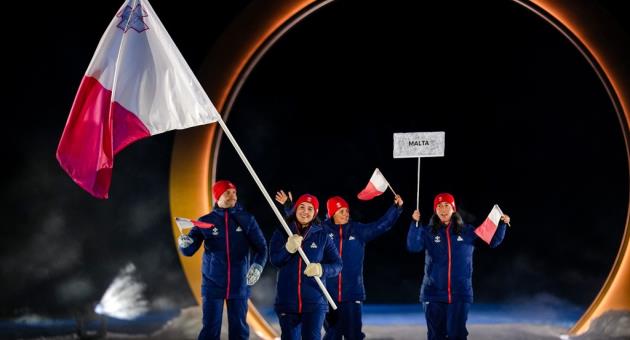 Jenny Axisa Eriksen, the flag bearer of Malta takes part in the athletes parade during the Olympic opening ceremony at the 2026 Winter Olympics, in Predazzo, Italy, Friday, Feb. 6, 2026. (AP Photo/Matthias Schrader)